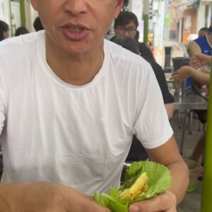 Bobby Chinn Instagram - Ok this is the continuation from the post on cooking the banh Xeo to eating it. So this is how you eat it. There is a etiquette, but not here, as I’m a little hungry and this is one of those dishes I miss and have craved since leaving.  Nobody makes it as good as here. What I love about many Vietnamese dishes is that it’s exciting in the palate, one bite can be weighted more with the flavour of the mustard greens with the smooth buttery crispiness  of the pancake, where the next bite can be punctuated with mint or  perilla leaves. Now the reason why you remove the stem of the mustard green and salad, is it makes it easier to fold and roll, otherwise it will crack and tear. #banhxeo #vietnamesestreetfood #streetfood
