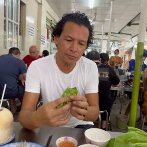 Bobby Chinn Instagram - Ok this is the continuation from the post on cooking the banh Xeo to eating it. So this is how you eat it. There is a etiquette, but not here, as I’m a little hungry and this is one of those dishes I miss and have craved since leaving.  Nobody makes it as good as here. What I love about many Vietnamese dishes is that it’s exciting in the palate, one bite can be weighted more with the flavour of the mustard greens with the smooth buttery crispiness  of the pancake, where the next bite can be punctuated with mint or  perilla leaves. Now the reason why you remove the stem of the mustard green and salad, is it makes it easier to fold and roll, otherwise it will crack and tear. #banhxeo #vietnamesestreetfood #streetfood