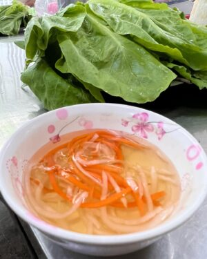 Bobby Chinn Instagram - Ok this is the continuation from the post on cooking the banh Xeo to eating it. So this is how you eat it. There is a etiquette, but not here, as I’m a little hungry and this is one of those dishes I miss and have craved since leaving.  Nobody makes it as good as here. What I love about many Vietnamese dishes is that it’s exciting in the palate, one bite can be weighted more with the flavour of the mustard greens with the smooth buttery crispiness  of the pancake, where the next bite can be punctuated with mint or  perilla leaves. Now the reason why you remove the stem of the mustard green and salad, is it makes it easier to fold and roll, otherwise it will crack and tear. #banhxeo #vietnamesestreetfood #streetfood