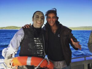 Brenton Thwaites Instagram - #tbt 
1. Arriving at Hamilton Is. with Javier. 
2. Ghost Pirate Blues. On the long boat journey to Whitehaven Beach the wind had picked up and the boats with cast and crew had trouble landing on the beach. Many-a-crew seeing their breakfast for the second time! Our cast boat was standing by for about an hour in the channel. I had a little travel guitar with me and Javier (who’s a drummer) banged on a few buckets. Ghost Pirate Blues was played in the bay! Was crazy fun and we were all semi-depressed when the weather subsided. 
Side note: two heli’s were reserved for team Jonny and AD’s. I wrapped a bit early and had been doing water work all day. Chris Costaldi (1stAD) gave me his heli and I was back on Hamilton (and in the pub) in 10 mins. Thanks Chris. Still has me smiling to myself.
;)
#pirates 
#whithavenbeach