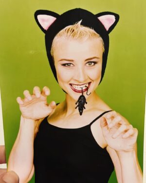 Cal Wilson Instagram - Cat Lady since way back. 

Looking through some old publicity pics. I’m going to say this is 2000/1. 
Publicity shot for my show “Hell Kitty.”
Photo by the amazing @emma__bass (you should check out her stunning floral artworks on her Insta). 
I’ve found an absolute treasure trove, I tell ya. 

(Image: a platinum blonde Cal, 20 years younger, and wearing a little black bonnet with cat ears, dangling a plastic rat from her teeth, doing cutesy claw paws with her hands. She is on a vibrant green background. My one regret is not being able to use it in my passport. 
“We’re not sure if it’s you, could you do the cat hands please?” “Meow” “Welcome to Australia”)

#throwback #comedy #StandUpComedy #Australia #NewZealand #MICF