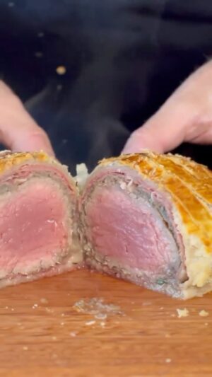 Carlos Bertolazzi Instagram - Hoje tem 🥩BEEF WELLINGTON 🥩

A temida receita feita de forma bem fácil 

1 peça do miolo de filé mignon 
1 colher de sopa de azeite 
1 colher de sopa de mostarda Dijon
Presunto Cru
200g de cogumelos frescos 
2 dentes de alho
Tomilho
Massa Folhada
Gema de ovo

1 pacote de ervilha congelada 
Água 
Folha de Louro
Mini cenoura

Sal e pimenta 

Prato: Linha Geo @portobrasilceramicaoficial 
Panelas: Linha Cooper @brinoxoficial 
Mesa e tábua: @woodfuturebrasil