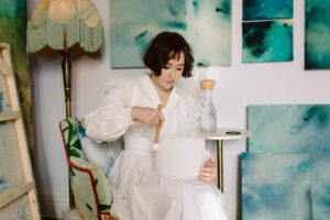 Christina Scherer Instagram - “The Meeting Place” opens TODAY! And will be @revelryboutiquegallery for the month :) 

This show is really special to me. All the paintings in this collection were painted on raw canvas and given an even layer of moon water **that had been activated by my two quartz crystal singing bowls**—heart and throat—before adding colors. 

The heart and throat chakras in the human system are where the feminine and masculine meet. 

I am getting married this year (in two months!) and wanted to visually explore the meeting of these two vibrations coming together. Allowing the water to be a visual representation of this “Meeting Place” without trying to control what it looks like. 

My hope is that the vibrations of love and authentic truth will activate whoever sees them—from the crystals bowls, into the water, and into the homes/spaces these paintings get to live in.

I hope you’ve enjoyed learning a bit about my first collection. 💙💚