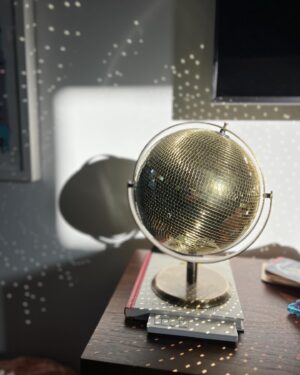 Cyrina Fiallo Instagram - Every day at around 6:18 pm, the sun shines through a window in my living room and hits the disco globe on my record stand, causing a kaleidoscope of lights all around. It has brought me the greatest joy for the last few weeks and I wanted to share this little piece of magic with you ✨🪩

✨

🪩

✨

🪩

#discoglobe #discolights #littlejoys #reflections #sunreflection #tinymoments #livingroomphotography #allofthelights