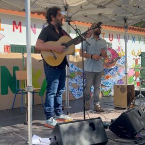 El Kanka Instagram - Hoy he estado en un oasis, y he sido mago.

Cuando le he dicho al taxista que me llevara a Los Asperones ha flipado. Me ha hecho el favor de dejarme en la puerta del colegio, pero añadiendo que normalmente los taxistas no entran a ese barrio…

Los Asperones es una barriada periférica, como tantas, formada por un crisol de chabolas malencajadas que constituyen una clara asignatura pendiente en mi ciudad. 

Dentro de ese barrio. Un oasis. Un colegio muy especial, un colegio de “cuidadanos” que, remando contra corriente, inculcan amor, cuidado, familiaridad, emociones e inteligencia a partes iguales… Afuera, estrellas en la pared con los nombres de los niños que han logrado terminar sus estudios, coronados por dos universitarios.

Ahí es donde he tenido el honor de tocar hoy. El profesorado ha estado enseñando valores al alumnado a través de mis humildes canciones, y, junto a su carismático director, hemos ido descubriendo un enorme mural intercalando momentos musicales, y unas cuantas decenas de niñas y niños han coreado, bailado, dado palmas y se han reído con nosotros. 

Luego me han dado muchísimos abrazos que me llevo para mi casa, y también una bandera simbólica de lunares, gitana, amorosa y pacifista que colocaré orgullosa en la balda más visible de mi estantería.

Hoy no ha sido un día normal. Tengo el corazoncito que parece un hula hoop.

Gracias al @ceip_mariadelao , a @brisa_festival  por apoyar proyectos tan humanos y necesarios como este, y a mi @el_manin_oficial por acompañarme y ayudarme a meterle el ritmo a los chiquillos en el cuerpo.