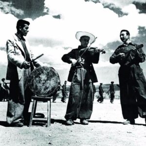 Ercan Kesal Instagram - Gördüğünüz Her Şeyi Kendileri Yaptılar

Bir Köy Enstitüsü’nün meydanı… 

Bu fotoğrafta sadece müzik aleti çalan üç öğrenci yok. Bu fotoğraftaki her şeyi kendileri yapan delikanlıların nihayet yaptıkları soylu ve coşkun bir müzik var. Davulu, kendileri yaptılar. Derisini tabakladılar, kasnağını gerdiler ve tabii ki çemberini. Tokmak kolay. Hemen yandaki ardıç ağacından kestiler. Kemanı kiraz ağacından kendileri oydular. Mandolin gürgenden. Telleri için ne kullandılar bilmiyorum ama kendileri yaptılar. 

Üzerlerine giydiklerini sonra. Pantolonlarını, gömleklerini ve ceketlerini kendileri diktiler. Davulun konduğu tabureyi de kendileri çaktılar. 

İşte şimdi sonsuz bir özgüvenle, kendi yaptıkları okullarının ve yatakhanelerinin önünde, kendi imal ettikleri enstrümanlarında, kendi yazdıkları şiirleri bestelemişler ve çalıyorlar. 

Bu fotoğrafta baştan sona onlara ait başka şeyler de var. Üzerlerinde mavi bulutlarıyla gezinen kocaman bir gökyüzü ve özgür bir dünya. Hepsi katıksız ve koşulsuzca onlara ait. 

Muktedirler hiç sevmezler böyle fotoğrafları. Bu yüzden, çok geçmedi hepsini de aldılar ellerinden ve bize bu güzel fotoğraflar kaldı…

Ercan Kesal (Zamanın İzinde)