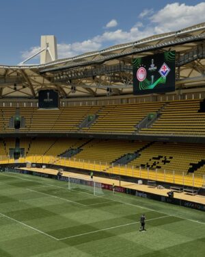 Gustavo Hofman Instagram - O estádio da final da Conference League nesta quarta-feira, entre Olympiacos e Fiorentina, será a OPAP Arena, casa do AEK, localizada no bairro de Nea Filadelfia, norte da capital grega. Logo ao sair da estação Perissos do metrô, a região é facilmente identificável com o AEK.

O Olympiacos é de Pireu, cidade portuária na região metropolitana de Atenas; seu estádio, Georgios Karaiskakis, está 14km distante do palco da decisão ao sul.

A UEFA determinou a capacidade da OPAP Arena, chamada pela entidade de Arena AEK para a final da Conference, em 27.100. Foram colocados à venda 21 mil ingressos, sendo nove mil destinados para cada clube; três mil para venda geral. Os demais ficam com a UEFA para fins institucionais e comerciais. Os preços aos torcedores tinham quatro categorias: Fans First: €25; Category 3: €45; Category 2: €85; Category 1: €125.

Pelas ruas da cidade, sem dúvida alguma e apesar da presença marcante da torcida da Viola, os torcedores do Olympiacos farão uma festa incrível. Dentro do estádio, as torcidas estarão mais equilibradas. #uecl