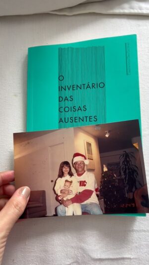 Isabel Wilker Instagram - Há alguns meses senti falta de uma foto minha com meu pai que adoro - uma comemoração de Natal de 1991, enquanto passávamos uma temporada em NY. Eu amo essa foto, e tava arrasada que ela tinha sumido. Já tinha catado em tudo que é lugar aqui em casa. Essa semana viajei para um trabalho e parei na estante pra escolher um livro pra viagem (o que eu estou lendo é meio grosso, não queria levar o peso extra). Escolhi esse da Carola Saavedra, e eis que, dentro dele, a foto. Achei uma coisa meio mágica essa foto estar perdida dentro de um livro com o título O Inventário das Coisas Ausentes. 
Sobre o livro: foi inteiro durante o voo de volta, 3 horas e 30 minutos de leitura. Comecei distraída, mas logo tudo sumiu e entrei em outro lugar, mais misterioso, melancólico, triste, mas também revelador e emocionante. E claro, por causa da foto, o livro se costurou à minha história com meu pai; a memória contida nessa foto, a falta dele, a presença dele. Uma frase, entre muitas outras coisas, que reverbera: não há disciplina para o tempo que passa.