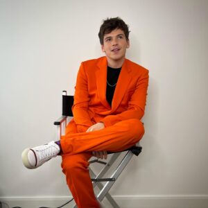 Jacob Dudman Instagram - Splash of colour 🍊 
For @fatenetflix press.

Styling: @ellalouisegaskell 
Make-up: @tonihowardmakeup 

Suit: @stellamccartney 
Chain: @tillysveaas 
T-shirt: @basicrights 
Shoes: @malonesouliers