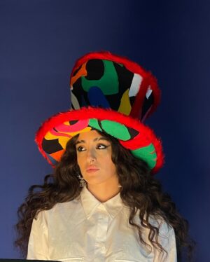 Juliette Motamed Instagram - I’M 6”8 WITH THAT BENNY ON ‼️‼️‼️

Thank you so much @bennyandallo for this bespoke Noize Top Hat. I never thought I’d see the day where I’d have a Crown that befits my Boundless Whimsy, but you’ve smashed it 💥😋💥

“I drew inspiration from one of AZADI.mp3’s DJ sets, where she fearlessly blended the sounds of her Iranian heritage with the pulsating beats of London club sonics, crafting a futuristic sound that echoes her diaspora narrative. Her eclectic taste in music subcultures serves as a driving force behind her aesthetic, seamlessly merging punk sensibilities with her cultural roots through sound.

For AZADI.mp3’s hat I sought to capture the boldness of her sonic creations while highlighting her distinctive Leo-esque hair. To visually represent the layers and textures of sound, I collaborated with artist @ed_curtis__ to design a multi-coloured applique textile, which was then
integrated into an oversized top hat shape. This fusion mirrors AZADI.mp3’s punk sensibilities and serves as a vibrant reflection of her fearless artistic vision.”
— @bennyandallo 

Come down to @dijonss tomorrow from 7-11pm to catch some of us @foundation.fm residents spin in our gorj crowns   to see me defy physics by balancing this guy atop my dome and headbangin 🫡

💜🎩💜
_____________________________
Final Portrait:
Photographer @elliotjameskennedy
Stylist @karen_binnszzzz
Hair @francesccardonahair
Makeup @makeup_gerri
Producer @franny_rollin
Photographer Assistant @rafski

supported by Foundation.FM (powered by @hiddenfashioninitiative)
@hiddenagency