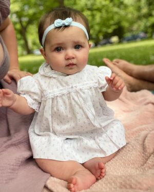 Katie Carpenter Instagram - we had a lovely picnic featuring my fave @hellyeahglutenfree treats 🍩 and FaceTiming with our mamas! 

Ryder came along too and isn’t 75 degrees the most PERFECT weather??! 

Cora is wearing a vintage dress made by my late grandma that I think I wore as a babe. 

And Kevin has been so sweet, he got me this beautiful birth stone necklace and printed out a poem that made me cry 🥹 (that we already spilled water on) 😂