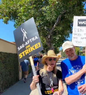 Kirsten Nelson Instagram - Day 1 & Day 73. We didn’t want a strike but we are not afraid of a fight. 
Back at Warner Bros. and man the picket line atmosphere has SKYROCKETED! 9am arrival & the lines were already packed (actors take that fucking calltime SERIOUSLY). Signs and tshirts needed to be restocked. Split the tent check-ins between gates for the Writers (Gate 4) and the Actors (Gate 2- freaking SMART!!). Stood with HUNDREDS if not a THOUSAND fellow laborers blowing whistles and cheering on the show of support from honking cars!! We’ve swollen the sidewalks around the studio to capacity!! God forbid we’re here another 73 days but our resolve is fierce and strong. Plus… I’ve got a new sign…

One day longer, one day stronger!
#SAGAFTRAstrike #WGAstrike #1u