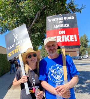 Kirsten Nelson Instagram - Day 1 & Day 73. We didn’t want a strike but we are not afraid of a fight. 
Back at Warner Bros. and man the picket line atmosphere has SKYROCKETED! 9am arrival & the lines were already packed (actors take that fucking calltime SERIOUSLY). Signs and tshirts needed to be restocked. Split the tent check-ins between gates for the Writers (Gate 4) and the Actors (Gate 2- freaking SMART!!). Stood with HUNDREDS if not a THOUSAND fellow laborers blowing whistles and cheering on the show of support from honking cars!! We’ve swollen the sidewalks around the studio to capacity!! God forbid we’re here another 73 days but our resolve is fierce and strong. Plus… I’ve got a new sign…

One day longer, one day stronger!
#SAGAFTRAstrike #WGAstrike #1u