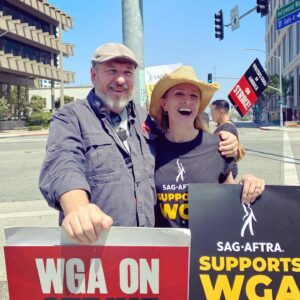 Kirsten Nelson Instagram - Another day, another picket line. At Warner Bros. with the Writers and BEYOND excited to run into WGA beastmaster @jonrog1!! Now about a minute ago we played a married couple in one of both our first sitcom pilots… and we were fabulous. Still happy to stand beside you and with you. Without your words, John, there wouldn’t have been that me. Forever grateful. #wgastrong #1u #sagaftrastrong