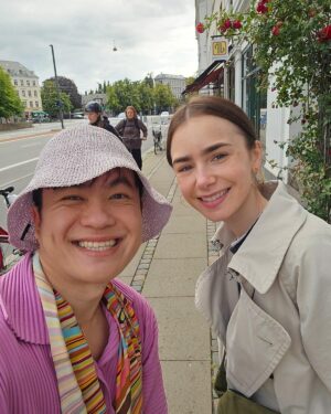 Kittiphak Thongauam Instagram - Omg ขณะที่กำลังเดินบ่นกับอากาศว่าเย็นแบบนี้ กูเอาแต่ชุดซัมเมอร์มา ละนี่ต้องเปลี่ยนแพลนมาใส่ชุดสีสันที่อุ่นสุดแล้วที่มีซึ่งกะจะใส่ที่สวีเดน ก็สวนกับผญ.คนนี้ที่จูงหมาอยู่หน้าคาเฟ่ นางยิ้มให้นี่ (คงคิดว่าสีสันอะไรคะชุด นี่โคเปนนะยะ55) นี่ก็ยิ้มให้นาง แล้วก็เอ๊ะ ใช่ใช่มะ? (ขอบคุณคอลัมน์คัทลียาจ๊ะจ๋าที่ทำให้นี่มีทักษะการจำหน้าคน) Are you Lily? นางยิ้มเขินๆ ก่อนตอบ Yes ก่อนที่สามีนางจะออกมา ซูปเปอร์ไนซ์มาก บอกว่าบางทีนางมาอยู่ที่นี่ คุยขิงข่าเรื่อง Emily ซีซั่นใหม่ที่กำลังจะออก นางก็คุยด้วย  ขอถ่ายรูปก็ให้ ใช้ซัมซุงถ่ายแบบยกมือไม่กดหน้าจอ นางก็บอกว่าเก๋มาก Make my day สุดๆ ขนาดว่าเดินไปร้านบรั้นช์ครึ่งชม. ก่อนจะพบว่าลืมเอาบัตรเครดิตมาต้องเดินกลับรร.มาเอาอีกครึ่งชม. และโพสต์อันนี้ระหว่างทางเดินกลับก็ยังยิ้มได้ 55 👩‍🎨🗼❤️