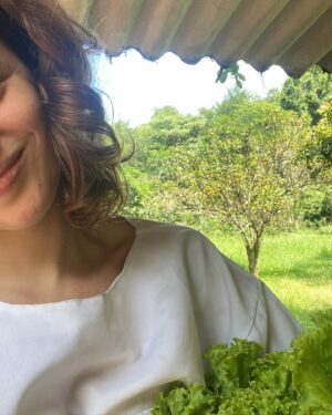Lara Tremouroux Instagram - De tudo o que o candomblé tem me devolvido: hoje celebro tanto ter um espaço que me reconecta à minha individualidade, ainda que e justamente por viver em conjunto. Ontem @maeanavieira me falou no ouvindo enquanto me dava o colo que só uma filha de Oxum poderia me dar, que viver em comunidade é estar de pé quando o outro não pode levantar. Ela tem me ensinado o valor desse lugar verdadeiramente genuíno de troca, do fazer pelo outro, estar com o outro, dar e receber. Como ela diz, não há ebó mais eficaz do que bom caráter. Ela me mostra que botar limites é ser amoroso, amor de mãe-onça, leoa, me ensina a coragem de me posicionar, defender os meus, a força que um laço de lealdade pode ter. É tanto, tanta coisa. Pra além do amor de Orixá, da relação com o sagrado, que eu não vou nem tentar articular em palavras porque não há espaço que caiba, tem também o fazer função, o básico do básico que conecta ao momento presente: lavar louça, lavar alface, tirar as plantas secas do caminho pra que caiam outras, e de novo e de novo, varrer chão, tirar lixo, lavar mais louça, o “concreto” da coisa. Semana passada tava super ansiosa com vida y futuro e com alguns dias em casa, nesse lugar que ganhei pra cuidar e me cuidar, pra dividir, lembrei que o caminho de volta pra si pode ser mais simples. Atotô ❤️