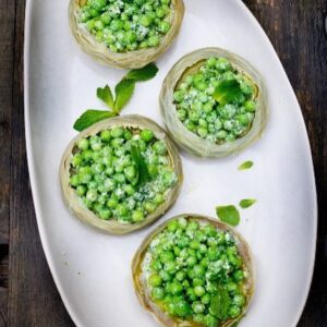 Laurent Mariotte Instagram - Quand les artichauts bretons rencontrent les petits pois de Provence voilà ce que ce donne 🫛 Pour les réunir  j’ai fait une belle vinaigrette à la fêta. Du soleil dans l’assiette ☀️ À vous de jouer la recette est là ⬇️
#petitsplatsenequilibre #petitspois #artichaut #vegetarien 
📸 @nicolasedwige 

4 artichauts camus ou fonds surgelés 
3 citrons
400g de petits pois à écosser ou 100g de petits pois écossés
1/2 botte de menthe
Quelques branches d’aneth
100g de féta
15cl d’huile d’olive
10cl de vinaigre à l’estragon
Sel gris fin, sel gris gros, poivre du moulin

Faites bouillir une grande casserole d’eau salée additionnée d’un jus de citron et de deux cuillères à soupe d’huile d’olive.

Effeuillez légèrement puis cassez la queue des artichauts. A l’aide d’un couteau bien aiguisé, tournez-les en les tamponnant régulièrement de citron afin qu’ils ne noircissent pas. Coupez les chapeaux pointus des feuilles restantes et plongez les artichauts dans l’eau bouillante. Déposez un papier absorbant sur le dessus, faites frémir pendant 20 minutes puis laissez refroidir dans l’eau de cuisson.

Pendant ce temps, écossez les petits pois et plongez-les 3 minutes dans une eau bouillante salée, refroidissez-les immédiatement dans une eau glacée puis égouttez-les.

Dans un bocal en verre, versez l’huile d’olive, le vinaigre à l’estragon et le jus d’un citron, mixez le tout. Ajoutez la féta, les feuilles d’aneth et mixez à nouveau jusqu’à obtenir un mélange plus ou moins lisse selon vos envies.

Dans un saladier, versez les petits pois avec la menthe ciselée, un peu de vinaigrette et mélangez.

Egouttez les fonds d’artichauts, retirez les foins puis déposez-les dans le plat de service. Garnissez de la salade de petits pois. Ajoutez un peu de sauce en décoration et terminez par un bouquet de menthe