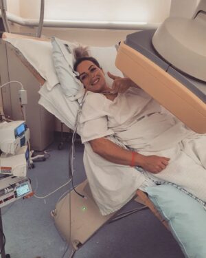 Leigh Holland-Keen Instagram - 3 weeks ago I underwent some pretty brutal surgery, surgery that I knew was risky but had to be done. I went to sleep after being told they would have to remove my left kidney, spleen, left ovary, part of my bowel, the 1kg liposarcoma and I'd have a "chemo washout" . I was so scared. It is so daunting being on your own and being faced with this. I also had an epidural prior to being sedated which brought back horrible memories of my birth but the team made me as comfortable as possible and gave me alot of reassurance which helped me in so many ways. 
.
.
I was extubated early as the surgery went well and I'm "fit and healthy" , the tumor was removed much easier than anticipated and they managed to keep the majority of my organs. I woke up with drips and drains coming out of everywhere - Arterial lines, central line, indwelling catheter, 2 abdominal drains, nasogastric tube, 3 intravenous cannulas, TPN, epidural infusion, and an oxycodone PCA. 
.
.
The next day, I had a cardiac arrest requiring CPR - I came round to a busy room full of medical staff racing around, working hard. I was told I would need a temporary pacing wire and the possibility of a pacemaker being inserted. After discussions with the cardiologist- they wanted to monitor me but attached to the defibrillator, an echocardiogram showed I have a bicuspid aortic valve with regurgitation (something I wasn't aware of). 
.
.
After 5 or 6 days in ICU I was finally moved to the ward - a few days in I developed an acute onset of new pain - I'd rather have back to back births than this pain again - I had an urgent CT at midnight to show I had pancreatitis. I was started on a continuous ketamine infusion which unfortunately made me hallucinate and I became agitated - that was stopped within 24hrs. After a couple of days things started to settle. Day by day, more drips and drains were being removed. I was in bed for 12 days so mobilising feels very weird and wobbly. 
.
.
This has certainly changed me - physically and mentally. I'll grow from this, I know it - but first I need to focus on getting my independence back and allowing myself to heal.