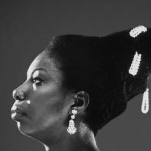 Lisa Simone Instagram - On 25 April 2003, in Carry le Rouet, the seaside town Mom called home, her funeral was held 4 days after she made her transition in the house she loved so dearly. My husband @robkelly714 and I departed NYC on the 22nd of April and landed in Marseille on the 23rd. I took one week off from my job playing Aida in AIDA, on Broadway, to make the journey and attend to affairs as best I could. The image of Mom and I sharing a kiss was taken in my dressing room at the Palace Theatre in NYC as she wished me well before taking her seat to watch my performance. Who knew it would be the last time we saw each other? Her funeral was attended by so many, including Miriam Makeba, the crowd overflowed into the street. Flowers from contemporaries, admirers, friends, dignitaries and politicians were everywhere as condolence letters from the Prime Minister of South Africa and the Foreign Minister of France, among others, were read. The minister who oversaw the ceremony called her an apostle.  When I took to the podium I sang PRECIOUS LORD and invited attendees to take a white rose to remember her by. As her casket, adorned with her favorite flowers and a banner that says it all, was carefully carried by pallbearers, cameras flashed; and as our limousine departed the church townspeople, on bicycles and on foot, raised white roses in salute as our limousine passed by. That very same banner now graces her piano. Hard to believe it has been 21 years! Nana Camille Yarborough was a friend of Mom’s, and her song PRAISE YOU felt right today. #ninasimone #remembered #whiteflowers #france