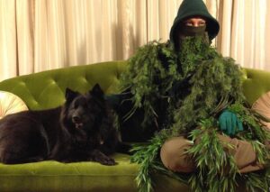 Mageina Tovah Instagram - Portrait of a Swamp Thing and Hound
.
📷🌿: yo
.
Image description: Mageina wears swamp thing attire and sits on a green velvet couch with a fluffy dog. 
.
#swamp #thing #portrait #selfportrait #photography #dog #dogsofinstagram #puppy #familiar