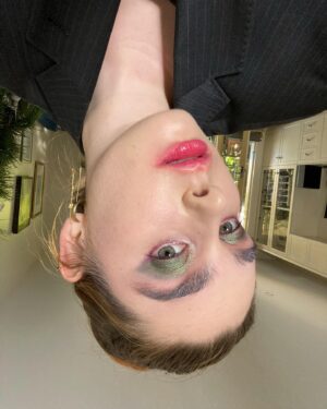 Maiah Stewardson Instagram - hewwo 🙃
[ID: a selfie of Maiah looking at the camera. They wear smudged red lipstick and dark green shimmer on their eyelids. The selfie is flipped upside down]