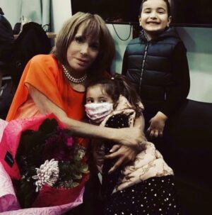 Mairi Hronopoulou Instagram - Ακολουθεί μεγάλο κείμενο. Μην το χάσετε! Φίλες, φίλοι γεια σας. Μέρες έχουμε να τα πούμε ε; Συνήθως όταν ψιλοεξαφανίζομαι κάτι ψιλό τρέχει με τα ψυχολογικά μου. 
Αυτή τη φορά όμως, κόντρα στον καιρό. Νιώθω ΕΚΤΑΚΤΑ!  Καλύτερα από ποτέ. 
Σοβαρή έλλειψη όμως είναι το πόσο μαθητευόμενη παραμένω στην καινούργια τεχνολογία. Απορώ πως μπορεί και με ανέχεται ο παλιός, καλός μου φίλος Γιαννης Αρμουτίδης που μου έφτιαξε αυτή τη σελίδα στο Instagram, και μου την ενημερώνει. Με πλήρη σεβασμό, γιατί ούτε ενα «και» αναγράφεται χωρίς να το έχω πει. Και τα σημεία στίξης είναι δικά μου. Αυτά για τα κείμενα που αναρτώ, ως και αυτά που απαντώ. Έτσι κάποιες πολύ όμορφες φωτογραφίες, τις είχα μπλοκάρει στο κινητό μου και μόνο ο μέγας ειδήμων Γιάννης τις ανέσυρε. Είναι από μια πανέμορφη εκδήλωση που έγινε στα τέλη  Δεκέμβρη στο «Φυσίαθλον». Και λέω πανέμορφη, γιατί οι συνδαιτυμόνες ήταν μικρά παιδάκια. Τοσούκιλα παιδάκια. Αγοράκια και κοριτσάκια που κάνουν χορό εκεί. Εκκλήθην να πω παραμύθι, σκάρωσα ενα στα πρόχειρα, αλλά τα παιδάκια γοητεύτηκαν. Με αγκαλιάσαν με ζουλήξαν, με λίγα λόγια εισέπραξα αγάπη για έναν χρόνο. Υπέροχη βραδιά! Άξια συμπαραστάτις μου η αγαπημένη μου Ευανθία Ρεμπούτσικα που λατρεύει κι αυτή τα παιδιά. Σας παραθέτω 5 στιγμιότυπα
