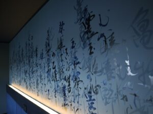Mami Instagram - “龍宮”
2024,06,24, 佐賀県嬉野市・和楽園
@warakuen_chagokoro 

素晴らしい旅館の50周年を記念し、リニューアルされた客室の内装を担当いたしました。

「書く文字はお任せします」
と３代目よりオーダーをいただき、”日本三大美肌の湯” として知られる嬉野の泉質に癒されつつ、頭を振り絞って考えました。

左の壁「龍宮」は、
壁：艶消し藍色
インク：艶ありのネイビー
※これからベッドが来るので下のスペース空けてます💤

右の壁「亀ものがたり」は、
壁：艶消し藍色
インク：艶あり黒、艶ありネイビー、艶消し青緑

3色で書いた「亀ものがたり」は角度により見え方が変わり、まるで立体物のような平面作品を完成させることができました。

また、「龍宮」の文字を選んだ理由は以下。

--

①和楽園入り口にある池の亀たちが、竜宮城の乙姫を慕っていたという「亀ものがたり」のお話よりインスピレーションを受けた。

②竜宮城には水の神様がいる。和楽園はお茶と温泉を大切にしていて、どちらも水が鍵となる。

③竜宮城に赴いた者へは宝物が与えられる。私自身も、和楽園にて沢山の宝物となる時間を過ごさせていただいた。

④和楽園から徒歩圏内に豊玉姫（別名：乙姫）をお祀りする神社があり、書く前に参拝した。

〜三代目より個人的なエピソードも入れてOKと言われたので〜

⑤和楽園に伺った２日間、爽やかな雨が降っていて、龍神様が喜んでいるように感じた。

⑥自分自身の中にも新しい命がいて、水（羊水）がとても大切。龍年に子供を授かり出産することと、和楽園も今年50周年を期に新たな挑戦をするということで、「竜宮」を「龍宮」と表記した。

--

和楽園さん50周年おめでとうございます。
そしてお招きいただき、特別な時間を作っていただき、ありがとうございます！！！
またすぐに行きたい♨️🍵　

#和楽園 #嬉野温泉 #嬉野茶
#書道家万美 #mamimozi #Calligraf2ity