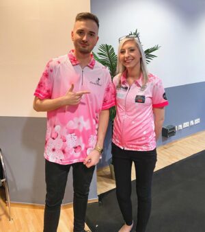 Marcel Althaus Instagram - Gestern habe ich bei der Ostsee-Darts-Gala in Kiel meine Wettschulden eingelöst und im Trikot von @fsherrock (eine der besten Frauen in Darts überhaupt) auf der Bühne gespielt. Ironischerweise wurden wir sogar gegeneinander gelost und es kam zu einem Krimi. Am Dienstag erfahrt ihr auf meinem Kanal ScorpionDarts vom Endergebnis. Sie ist echt eine kranke Spielerin und liefert den Beweis, dass Frauen im Darts absolut wettbewerbsfähig sind! Geile Nummer gewesen! 🎯🎯🎯 Werbung weil Markierung lol