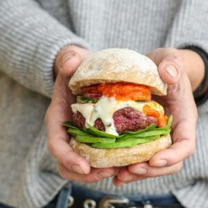 Maria Dias Instagram - 🌱HAMBURGUER DE BETERRABA E NOZES🌱
 
Receita do livro Ecoguia para Mudar o Mundo
 
Adoro a textura destes hambúrgueres e o sabor profundo e fumado. Ficam bons no pão mas eu confesso que os adoro simples. Faço-os mais pequenos e devoro-os como snack. Mesmo se não for à bola com a beterraba, experimente, tenho a certeza de que irá adorar.

Para cerca de 10 hambúrgueres

* 1 cebola
* 1 dente de alho
* 2 c. sopa de azeite
* 2 chávenas de feijão preto cozido
* ½ chávena de nozes
* uma mão cheia de coentros frescos
* 1 beterraba ralada
* 1 cenoura ralada
* 4 c. sopa de farinha de aveia
* 8 c. sopa de linhaça moída
* uma pitada de sal
* 1 c. chá de pimenta caiena (opcional)
* 1 c. sopa de paprica fumada
 
Corte a cebola em meias luas finas e esmague o dente de alho.

Refogue a cebola e o alho no azeite até alourar. Reserve.

Triture as nozes no processador até ficarem numa areia granulada.

Escorra muito bem o feijão para que fique sem líquido. Junte o feijão e a cebola e triture até ficar cremoso.

Coloque esta mistura numa taça e adicione todos os restantes ingredientes.

Deixar repousar 15 mn a uma noite. 

Faça bolas e achate em forma de hambúrguer, se necessário com ajuda de um molde. 

Coloque os hambúrgueres numa frigideira quente untada com um pouco de azeite. Cuidado ao virar para não se desfazerem. 

Agora experimente e maravilhe-se. Os legumes têm ou não superpoderes?

E as minhas unhas nesta foto? Felizes de terem andado a cozinhar demais e esgravatar a terra 😄

Foto da @barbara.tomaz.foodstyling