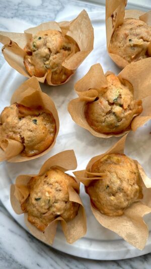 Megan Mitchell Instagram - 95% of my time is thinking about what and how to feed my kids. Most of the time it ends in defeat as I throw raisin bread on the table and say I can’t work like this! It’s really fun for everyone. I did manage to get some veggies into these banana muffins and they were consumed happily, by both me and my toddler. If you also feel that your talents aren’t appreciated in the kitchen, give this recipe a try👇🏼⁣
⁣
Banana, Zucchini and Carrot Muffins⁣
⁣
Ingredients:⁣
• Cooking spray⁣
• 1 1/2 cups AP flour⁣
• 1 tsp. cinnamon⁣
• 1 tsp. baking powder⁣
• 1/2 tsp. baking soda⁣
• 1/2 tsp. fine sea salt⁣
• 1 egg⁣
• 1/2 cup vegetable oil⁣
• 1/2 cup granulated sugar⁣
• 1/4 cup whole milk⁣
• 2 medium ripe bananas, mashed⁣
• 1 cup shredded zucchini, liquid squeezed out (about 1 medium zucchini)⁣
• 1 cup freshly shredded carrots (about 2 small carrots)⁣
⁣
Directions:⁣
• Preheat oven to 350℉. Line 2 muffin tins with 18 liners and lightly spray with cooking spray⁣
• In a large bowl whisk together the flour, cinnamon, baking powder, baking soda and salt⁣
• In a medium bowl whisk together the egg, oil, sugar and milk. Switch to a spoon or spatula and pour the wet into the dry, mixing until you no longer see any dry bits⁣
• Lastly stir in the bananas, zucchini and carrots. Mix just until combined⁣
• Using a large portion scoop or ice cream scoop, fill the muffin liners 2/3 full⁣
• Bake for 10 minutes, rotate the tins and bake for another 12-15 minutes or until puffed, golden brown and a toothpick inserted in the middle comes out clean⁣
• Remove from the muffin tins and let cool fully on a cooling rack
