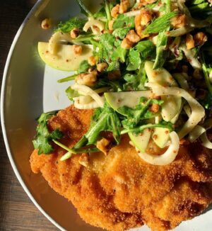 Megan Mitchell Instagram - Crispy chicken cutlets with an arugula, apple, walnut and fennel salad👇🏼⁣
⁣
Ingredients:⁣
• Canola oil, for a shallow fry⁣
• 2 8-ounce boneless, skinless chicken breasts⁣
• 1/4 cup AP flour⁣
• 1 egg⁣
• 3/4 cup plain breadcrumbs⁣
• 1 tsp. kosher salt, divided⁣
• 1 tsp. freshly cracked black pepper, divided⁣
• 1/4 tsp. garlic powder⁣
FOR THE SALAD:⁣
• 3 tbsp. extra virgin olive oil⁣
• 2 tbsp. apple cider vinegar⁣
• 1 tbsp. whole grain mustard⁣
• 2 tsp. dijon⁣
• 2 tsp. maple syrup⁣
• Kosher salt, to taste⁣
• Freshly cracked black pepper, to taste⁣
• 1 small head fennel, cut in half lengthwise and then thinly sliced into half-moons, fronds reserved⁣
• 1/2 granny smith apple, cut into thin half-moon slices⁣
• 2 lightly packed cups baby arugula⁣
• 1/2 cup chopped walnuts, toasted⁣
⁣
Directions: ⁣
• Fill a 14-inch cast iron skillet halfway with oil. Bring up to heat over medium to 350F⁣
• Place 1 breast at a time into a gallon sized resealable bag. Using a rolling pin or the flat side of a meat tenderizer, evenly pound out the breast to 1/4-inch thick. Remove and continue with the 2nd breast. Remove⁣
• To the same bag add 1/2 tsp. of salt and 1/2 tsp. pepper along with the flour and shake⁣
• Add 1 breast at a time and shake to coat⁣
• In a medium shallow bowl crack the egg and beat. To another medium shallow bowl add the breadcrumbs, 1/2 tsp. salt, 1/2 tsp. pepper and garlic powder. Mix⁣
• Take the floured breasts, one at a time, and place in the egg, coating both sides and then place into the breadcrumbs, pressing the mixture in. Place back onto the plate and continue with the other breast⁣
• Carefully add both chicken breasts to the skillet and cook 2-3 minutes per side until golden brown and crispy. Remove to a sheet tray lined with a cooling rack and keep warm in a low oven while you make the salad⁣
• To a large bowl add the EVOO, vinegar, whole grain mustard, dijon, maple syrup and a large pinch of salt and pepper. Whisk together then add in the sliced fennel, apple, arugula and walnuts. Toss and taste for seasoning⁣
• To serve plate the chicken cutlet with some of the salad and garnish with the reserved fennel fronds