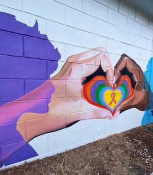 Melanie Posner Instagram - When looking at this mural you wouldn’t know that it’s unfinished. It was supposed to have a tagline at the top that read “It takes every community,” with a QR code that led to The Ryan White Care Council’s website. This mural was fully funded by this organization to raise awareness and beautify the community. Unfortunately the building owner of where this is located changed his mind mid project (because he donated his wall to us) and I had to stop painting. We sadly had to leave this project unfinished for 6 months. All this time- behind the scenes- despite getting threatened for trespassing or defacing property if I finished the mural, I fought so it could be complete. The message in my art is so important to me. I wanted to portray diversity, inclusivity, and togetherness. With the state that Florida is in right now we need that more than ever. So after blood, sweat, and tears I’m glad I could finally come back and leave the neighborhood with this. Always fight for what you believe in 🫶🏼It’s located on the side of Nicko’s Pizza in DTSP ❤️ Please note that the pizza shop was in equal outrage as me, they just rent from the building owner, and you should go support them. 
.
.
.
.
.

#DTSP #stpetemurals #stpeteart #muralartist #lgbtqart #womenwhopaint #stpetersburgfl