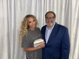 Michael Eric Dyson Instagram - 8/9/23 8:11pm
It is 44 minutes before her show in Charlotte. The most gifted entertainer the globe has ever seen is improbably serene in her spacious yet understated dressing room. She is sheathed in a modest charcoal tee shirt that pays quiet tribute to her riveting world tour. There is little to suggest the storm of Black genius she is about to rain down on her eagerly waiting audience. She has graciously invited me into her placid makeshift sanctum to say hello — permitting me to thank her for her excellence on and off stage. But it is she who, in her astonishing humility, offers gratitude for the love and support shown her. All the while as we speak her daughter and niece play at the edges of our conversation, and like the great mother she is, she juggles her maternal care with sweet attention to the flow and substance of our pleasant encounter. All of us hug and pray and exchange love and affection for the Spirit of the Most High reflected in our midst, and then we snap this photo and I disappear into the crowd to witness a spectacle the likes of which we have rarely seen. I carry within me the incandescent memory of this great artist, woman, wife, mother, daughter, sister, feminist, humanitarian, friend, and performer whose scintillating sanctuary offers more love and concern and compassion and ministry than a thousand churches and temples and places of worship that scold and berate and upbraid in the name of a punishing God. All Hail The Queen! @beyonce