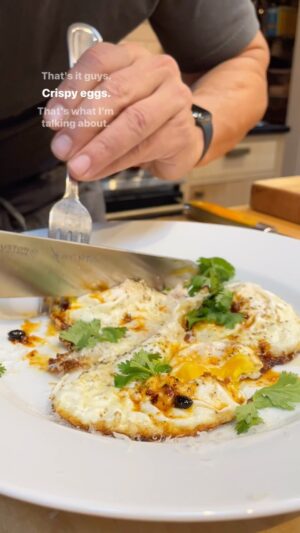 Michael Symon Instagram - These are the eggs that I grew up on… just in time for the weekend. I love eggs in all forms, but this might be my favorite. 

Crispy Eggs

Serves 1 

3 fresh eggs
¼ cup olive oil
2 tbl grated parmesan cheese
Salt & pepper to taste
Chili crunch (optional)

Heat fry pan until hot. Add olive oil to pan, continue to heat until it is shimmering. Crack the eggs into the hot oil. Baste the top of the eggs with the hot oil as the bottom begins to get crispy. Continue to cook until the top of the eggs are cooked and the bottoms are crispy and brown. Transfer to a plate, grate fresh parmesan cheese on top. Chili crunch can be added for spice and texture.
Enjoy.