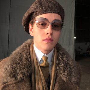 Michele Clapton Instagram - Conrad suits.  Ok you might be bored of me showing these costumes by now.. but if you are then look away! I just love to go back and remember/enjoy our work, as it’s sometimes so hard to do so in the thick of filming. These are fitting photos so the costumes are unfinished.
We loved our fittings with Harris Dickinson who played Conrad. It’s often difficult for younger actors used to wearing sports wear to feel comfortable in period cut clothes, especially the stiff high collars, so we spend time in fittings with the choreography of a costume, how it makes you walk and stand.. it’s a real aid. Harris bought so much to this role and ended up loving this style…he really made the costumes his own and we loved that his body shape was so good for the period cut.. the modern muscular shoulders and arms are more difficult to accommodate in these narrow suits.. Matthew Vaughn the director is obsessed by the cut and fall of mens suits so he really kept us on our toes. We made some suits in our work room cut by the wonderful Tim Perkins and others were made by the incredible Campbell and his team at Huntsman. The final suit here was one of my favourites and much lighter weight, it was the most unusual, quite American in cut, I liked it for the scene in Sarajevo. It was really difficult fabric to work with and we had to make multiples for the stunt scene.. Campbell was not impressed! But it turned out great! Shoes by George Cleverley complete the looks and glasses made to our design by Cuttler and Gross. Klaire Jamin on buying duty again killed it..along with assistant designers Alex Fordham,
Sophie O’Neill, Emma O’Loughlin, illustrator Simon Thorpe 
@huntsmansavilerow @timjohnperkins @sim0ndo @cutlerandgross @georgecleverley
