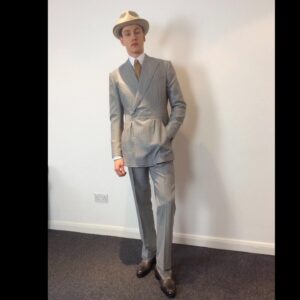 Michele Clapton Instagram - Conrad suits.  Ok you might be bored of me showing these costumes by now.. but if you are then look away! I just love to go back and remember/enjoy our work, as it’s sometimes so hard to do so in the thick of filming. These are fitting photos so the costumes are unfinished.
We loved our fittings with Harris Dickinson who played Conrad. It’s often difficult for younger actors used to wearing sports wear to feel comfortable in period cut clothes, especially the stiff high collars, so we spend time in fittings with the choreography of a costume, how it makes you walk and stand.. it’s a real aid. Harris bought so much to this role and ended up loving this style…he really made the costumes his own and we loved that his body shape was so good for the period cut.. the modern muscular shoulders and arms are more difficult to accommodate in these narrow suits.. Matthew Vaughn the director is obsessed by the cut and fall of mens suits so he really kept us on our toes. We made some suits in our work room cut by the wonderful Tim Perkins and others were made by the incredible Campbell and his team at Huntsman. The final suit here was one of my favourites and much lighter weight, it was the most unusual, quite American in cut, I liked it for the scene in Sarajevo. It was really difficult fabric to work with and we had to make multiples for the stunt scene.. Campbell was not impressed! But it turned out great! Shoes by George Cleverley complete the looks and glasses made to our design by Cuttler and Gross. Klaire Jamin on buying duty again killed it..along with assistant designers Alex Fordham,
Sophie O’Neill, Emma O’Loughlin, illustrator Simon Thorpe 
@huntsmansavilerow @timjohnperkins @sim0ndo @cutlerandgross @georgecleverley