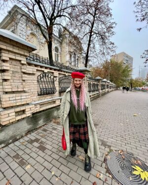 Oleksandra Hontar Instagram - восени хочеться відчувати себе студенткою якогось престижного коледжу, які ми зазвичай спостерігаємо у західних фільмах чи серіалах. щоб мати якусь утилітарну форму, шкіряний рюкзак, думати про філософські течії, уявляти свої аргументи у дискусіях на заняттях, з кимось дружити, проти когось дружити і загалом займатися тим, що згодом (з дорослішанням) буде вже не таким привабливим

з цими думками я два дні поспіль ходила у цьому луку, хоча він і далекий від моєї омріяної утилітарності 

але думаю, що поєднання червоного і зеленого якраз і натякає на ці класичні уніформи, як і клітинка на спідниці 

не відкидаю й того, що на студентські флешбеки мене наштовхнула книга «таємна історія» донни тартт, яку читаю для книжкового клубу @theukrainians 

ви ще теж можете встигнути до жовтневого клубу приготуватися — він має бути у понеділок. для участі у ньому треба долучитися до спільноти the ukrainians

у «таємній історії» йдеться про студентів, які вивчають греку у коледжі, і потрапляють майже у вир античної трагедії. це книга про дорослішання, незворотність, юнацький максималізм, що відбуваються на фоні містичних і трагічних подій 

трохи відвикла читати довгу художню літературу, але цей процес теж флешбечить у студентське минуле, де для цього всього було купа часу (і відсутність нетфліксу)))

у будь-якому разі, рада нагоді зануритися у читання заради читання, а не заради прикладних цілей типу збагнути цей світ або дізнатися щось нове 

тому от вам теж ключ до відчуття себе студентом (окрім пародії на уніформу, яка дарує бажання вештатись осінніми вулицями і ходити до водойм): візьміть якусь художню книгу і пройміться довірою до неї

а я пішла далі ностальгували за юністю і вигадувати шмотки типу я завтра йду на пари