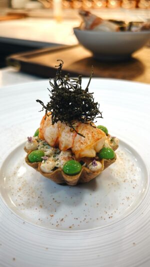 Paul Ainsworth Instagram - Throughout the year at @no6padstow, our ‘Land & Sea’ course takes on a number of forms. Changing with the seasons and as new produce appears on the menu. 

Through the early spring, we’ve been making the most of those beautiful creel-caught langoustines from the Western Isles of Scotland that I mentioned in my last post and, as with many of our dishes, this one uses every little bit of that incredible crustacean. 

We start with our seaweed and toasted caraway shortcrust pastry tart, beautiful crisp and really buttery. We fill it with a langoustine ‘tartare’ - all that incredible sweet knuckle and claw meat - bound with a fresh horseradish emulsion and some of the first sweet English peas of the season. 

On top, we place a perfect nugget of the langoustine tail, naturally so sweet and tender, which we’ve gently roasted over the coals and brushed with an oil made from the langoustine heads. Lastly, we top with crisp Cornish sugar kelp and a dusting of a powder also made from the rest of the shells. 🙏🏽💥🔥🦐👊🏾