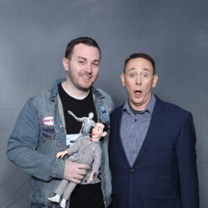 Paul Reubens Instagram - 🚲 "I can't remember a time in my life where a Pee-wee/Paul project wasn't in the backdrop," shares Brandon Hall, who's been stanning Pee-wee his entire life. In childhood, he got his mom to rent 'Pee-wee’s Big Adventure’ many many times. When that video store was going out of business years later, he bought the exact copy of the movie and then had Paul sign it! 📼

🦇 "At 5 years old, I remember being so excited to see ‘Batman Returns’ because TV Guide said Paul had a cameo," he recalls, “I can clearly remember watching it with my dad (before I could read) and insisting that he point out Paul's name in the credits.”

📚 "When I started kindergarten, I was introduced to the school library," Brandon reminisces about discovering 'Big Top Pee-wee' books. These books became a staple of his library visits, eventually gifted to him by the librarian at the end of 6th grade. 

🎭 Seeing Pee-wee live on Broadway, twice!, was a dream come true. "What a thrilling moment in my life," he reflects. You’ll see in his photo that he dressed the part! 🌟

👫 Brandon's passion for Pee-wee extended to those around him. "I've successfully introduced nieces, nephews, cousins, girlfriends, co-workers, and friends to the work of Paul," he says proudly. Meeting Paul at a convention was a highlight, as he felt a genuine appreciation for his fans. 

💌 After meeting Paul, Brandon got a surprise email from him asking for his mailing address. "From Christmas 2017-2022, I received a card from him and looked forward to it every year." 

🧸 "My old Pee-wee pajamas didn't fit anymore and my mom saved them and had them made into a keepsake bear," he shares about a heartwarming and adorable Christmas gift. 🐻

💍 Lastly, Brandon’s story takes a romantic turn with his engagement this summer at a drive-in during 'Pee-wee's Big Adventure.' "I popped the question over the radio while she was sitting in the car," he recalls. A perfect proposal for a lifelong fan. 🎥💕

Today’s Secret Word, as chosen by Brandon, is #YEAR! You know what to do when you hear the Secret Word, right? 😱😱😱

#PeeweeForever