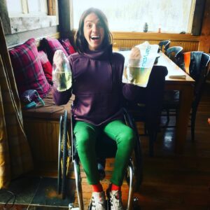 Quinn Brett Instagram - Oh shit!!!!! Forgot to squeeze the last #sciawarenessmonth post before October. 
.

.
.
Where did we leave off with 💩?! 
Fingering out the specifics…..literally. 
.
.
.
As mentioned in last post, there are 4 methods to assist our stubborn lack of signaling from the brain to our balloon knot gate keeper; manual removal (bearing down-pushing etc), digital stimulation (sticking a finger thru the stinky freckle to stimulate pooping and/or finger it out) , suppository (push magic bullet thru rusty Cheerio.  Wait 20 minutes or more for bowel & intestines to react and hopefully poop), and/or mini-enema (faster working version of a suppository, insurance rarely covers). 
.
.
.
Some of us sit in the porcelain office for 10 minutes, others for 2 hours or more.  Some of us with less finger dexterity—or none use special tools or personal care attendants. This process, to me, was humiliating at first.  It still can be even now on camping trips or sharing a hotel room. Sitting on the toilet for extended times, sticking a finger in my ass, #rubbergloves the uncertainty if poop is not interested in the swimming pool below. If not, would I then have an accident later in the day!  #rememeberihavenosenseofsmell #spinalcorsinjurymeanslossofsensationtoo
.
.
.
The most important part of not feeling our bowels, the crossed-up or dead wire aka Spinal Cord and last nights 🥃 doing its work is creating a poop routine.  Like every morning or every night.  Some do their poop routine every other day due to the time consuming nature of the routine. 
.
.
.
Now you know!  Spinal Cord Injury is the gift that keeps on giving! 🤩😤🤡. Cheers!!!
.
.
{image description: a brown haired Caucasia woman sits in her wheelchair.  She looks excited, holding  up a clear bag filled with urine in one hand, and in the other a clear Playtypus bag of white wine. 🤷🏼‍♀️#annashut 

.
.
.
.
.
.
.
.
.
#climbing #rockclimbing #enduranceathlete #skiing #mountains #mountainbiking #trailrunning #running #roadbiking #crossfit #yoga #paragliding #outdoors #athlete #spinalcordinjury #spinalcordresearch #paralyzed #medicine #walking #peeing #protectpubliclands #nationalparks #summitsforall #wilderness #disability