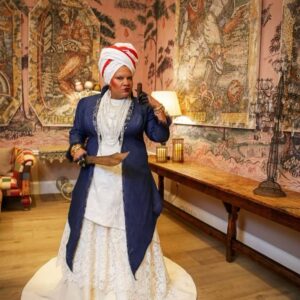 Radha Blank Instagram - OBEAH WOMAN, COME INTO THE ROOM!
A Prologue.
I’d been invited to remix a room in the #metcostumeinstitute #americanwing for their #inamerica exhibit. I integrated the dress of designer Maria Hollander, a White woman abolitionist. But when I asked who made the dress and her politically charged quilt seen in the exhibit, the seamstress remained unknown. This was chance to take #metgala invitation from a red carpet moment to a truth telling one. I would create a visual prologue to my #wegoodthx! installation. (More on the actual exhibit in the next post! I see you @hairbysusy @africancreature 😘)

I would rep a woman who could have made Hollander’s dress- an Obeah Woman who by day used her hands to sew, cook, wash White folk clothes & tend to their chirren and by night used her hands to conjure spells for our survival using ancestral African spiritual practices not meant to survive the middle passage. This would be my homage to Marie Laveau but also The Condomble Woman, The Santeria Priestess, The Ifa Woman, The Yoruba Priestess. The Voodoo Vixen and all women practitioners of ancestral arts from Africa.

This woman would represent the unseen Black women who have sewn the fabric of this country but she would also be my armor as faces and bodies like mine aren’t usually seen or celebrated in these spaces. 

Because I was invited a lil late to the party, I had less than five weeks to make something happen. The first person I called was the amazing @bevysmith, fashion and cultural writer & warrior who encouraged me to take my vision all the way. Knowing I needed a Black designer, Bevy suggested I reach out to @brandicedaniel founder of @harlemsfashionrow. Brandice being brilliant and knowing most Black designers were booked, suggested I reach out to dressmaker Jennifer McFarlane aka @jennycouture, a Jamaican American master craftswoman. When I mentioned “Obeah Woman” to Jenny, she hummed deep and I could feel her lips curling through the phone! And so with a design I co-created with my very best friend of thirty plus years @denise.trotman ….
Caption finished in post below….

(Special shout out to me & Peters assistant Chris Reyes  @crey_j for putting in that WORK!)