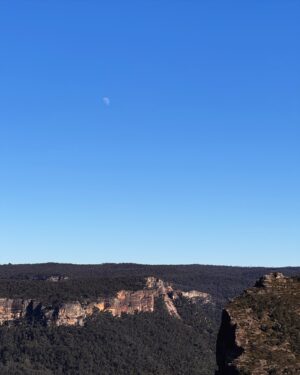 Rae Johnston Instagram - The sun and moon sharing the sky, sandstone paths, grass trees, huge ancient cliff faces, and that beautiful river flowing in the deep valley below 🤎 

Today’s walk on Wiradjuri, Darug & Gundungurra Country - making the most of the clear skies while they last, looking wet and below freezing next week! 

#bluemountains #rigbyhill #piercespass #wiradjuricountry #darugcountry #gundungurracountry