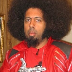 Reggie Watts Instagram - I don’t know what I’m doing with my mouth, but the message is clear…(please note the Jackson jacket/glove and Kraftwerk shirt)