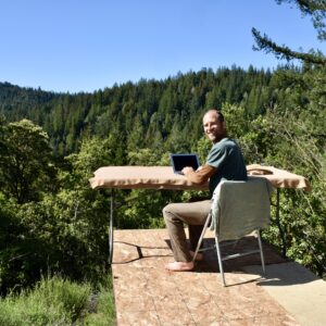 Rob Greenfield Instagram - This is where I have been for the last week and where I will be for now.
I am here to complete my Food Freedom book. It has been a long journey and I thought I would have completed this many times already. This is the time!

I’m in the Santa Cruz Mountains of Northern California staying on the edge of an off the grid property surrounded by hundreds of acres of forest! The property is owned by a couple who found my first book in a used book store about 7 years ago and has followed me since.

This platform serves as my desk to write with a healing view of the forest.
There is a solar panel and battery on site to charge my laptop.
There is a spring with fresh drinking water, and a bathtub to fill up and take my cold dips.
I am sleeping in my tent under the trees.
I have my wild rice, dehydrated mushrooms, greens, herbs and other dry and canned food from my last year of foraging. I’m cooking over wood from the forest with my small wood stove. I am foraging the spring greens that I can find and enjoying some herbs from the garden on site.
Wifi is a 5 to 10 minute walk away at Martha and Dan’s.
My basic needs are met.

It is quite alive here with birds and insects. A small songbird landed on my head twice while I was sitting at this table writing. Hummingbirds land daily just feet from me on a branch, interacting with me. A large male turkey very clearly told me that this is his domain, not mine. The frogs have kept me company with their evening croaking and have laid eggs in my bath as well!
Some days it is a bit chilly to be writing outside but I am grateful for all the Earth provides. I have hundreds of friends here amongst the plants and animals. 

This has been a nourishing and peaceful place to be after my month in Los Angeles. I have spent multiple days in silence and solitude and have had many long nights in bed, catching up on rest. 

I am elated to provide Food Freedom to you in June. I would love for every one of you to have this book in your hands.
I’m offering it on a donation basis, so it is accessible to everyone, no matter their financial situation. 

You are welcome to order the book now at robingreenfield.org/shop/foodfreedom

Love,
Robin