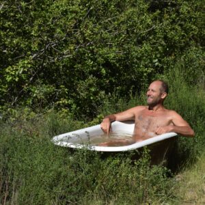 Rob Greenfield Instagram - This is where I have been for the last week and where I will be for now.
I am here to complete my Food Freedom book. It has been a long journey and I thought I would have completed this many times already. This is the time!

I’m in the Santa Cruz Mountains of Northern California staying on the edge of an off the grid property surrounded by hundreds of acres of forest! The property is owned by a couple who found my first book in a used book store about 7 years ago and has followed me since.

This platform serves as my desk to write with a healing view of the forest.
There is a solar panel and battery on site to charge my laptop.
There is a spring with fresh drinking water, and a bathtub to fill up and take my cold dips.
I am sleeping in my tent under the trees.
I have my wild rice, dehydrated mushrooms, greens, herbs and other dry and canned food from my last year of foraging. I’m cooking over wood from the forest with my small wood stove. I am foraging the spring greens that I can find and enjoying some herbs from the garden on site.
Wifi is a 5 to 10 minute walk away at Martha and Dan’s.
My basic needs are met.

It is quite alive here with birds and insects. A small songbird landed on my head twice while I was sitting at this table writing. Hummingbirds land daily just feet from me on a branch, interacting with me. A large male turkey very clearly told me that this is his domain, not mine. The frogs have kept me company with their evening croaking and have laid eggs in my bath as well!
Some days it is a bit chilly to be writing outside but I am grateful for all the Earth provides. I have hundreds of friends here amongst the plants and animals. 

This has been a nourishing and peaceful place to be after my month in Los Angeles. I have spent multiple days in silence and solitude and have had many long nights in bed, catching up on rest. 

I am elated to provide Food Freedom to you in June. I would love for every one of you to have this book in your hands.
I’m offering it on a donation basis, so it is accessible to everyone, no matter their financial situation. 

You are welcome to order the book now at robingreenfield.org/shop/foodfreedom

Love,
Robin