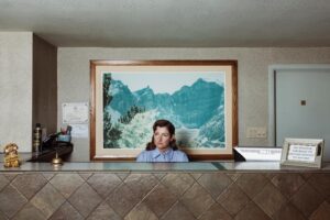 Robin de Puy Instagram - Robin as The Receptionist, Ely, Nevada

For her new project The Receptionist, De Puy dives into the role of motel/hotel receptionist. Having grown up in a hotel herself, she knows the role of the receptionist all too well, because it is something she has done since childhood. Many people have shared their stories with her: where they have come from, and what they have experienced. Sometimes, it is not so much about the stories as it is about the contact itself; finally, someone who will listen to you.

A motel owner from Raton, New Mexico, casually pointed the importance of motels out to De Puy: "You know, you have to realize that we are probably the only representatives to our city for a visitor. Because they stay with us and probably have no contact with anyone else, except maybe the guy at the gas station or the staff at the restaurant. In fact, we have a responsibility to make sure that we can help people, be their friend, whatever their needs are. We are connected."

And that is exactly how it feels for De Puy and what still rings true to her. A motel — or a hotel — is a place where there will always be someone there to lend an ear if you need one, regardless of your ideas, views, or opinions. When De Puy travels, she actually does the same thing. She first goes to the person behind the reception desk of the motel/hotel. A motel is an inexhaustible source of stories, a place where you can be curious, where you can withdraw or reveal yourself. Sometimes it is even a place where life begins or even ends.  
The Receptionist is an ode to the hotel industry and everyone working in it.

Many thanks to the greatest team: @mvrossem @sam.verberne @sandragovershairandmakeup @banana_wessner