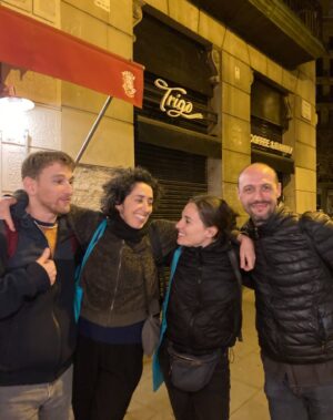 Sara Barros Leitão Instagram - Memórias de uma viagem a Barcelona para encenar uma leitura de um texto que escrevi para o Teatro Nacional da Catalunha. 

Este ano, foi Portugal o país escolhido pelo Teatro Nacional da Catalunha para se apresentar na Dramaturgia Emergente Europeia. Passei uma semana em Barcelona, guiada pela mão conhecedora do Manuel Tur, que encenou uma leitura do texto da Joana Craveiro, "Viagem a Portugal", enquanto eu encenava uma leitura do texto que escrevi propositadamente para este momento, "Regras para um beijo". É difícil descrever o quão bem recebidos fomos. Tínhamos um palco e uma equipa à nossa espera, e pudemos criar as leituras à escala do que éramos capazes de imaginar. Não fomos comedidos no amor que entregámos aos nossos atores, que confiaram em nós, na nossa direção e, no meu caso, que gentilmente me ofereceram a oportunidade de ouvir pela primeira vez o meu texto nas vozes de outros. Assim como entregámos parte do nosso coração e da nossa gratidão a toda a equipa que nos acolheu, que nos escutou, que assistiu atentamente a todos os ensaios, que imaginou soluções e antecipou problemas. O companheirismo, dedicação e rigor do Adrià Pinar foi essencial. Entrou nas nossas cabeças e transformou em luz, som e cenário a forma das nossas ideias. 

A par disso, há mais uma coleção de fotografias que não partilho aqui, mas que me acompanharão na memória de uma viagem maravilhosa. Visitámos a Sala Beckett, vimos um espetáculo brilhante no Teatre Lliure, comemos muito Ramen, batatas bravas e anchovas, vimos uma exposição sobre o SAAL e sobre processos semelhantes em Espanha e Itália nos pós-didaturas, caminhámos muito, fomos legalmente assaltados quando descobrimos o preço do brunch que acabáramos de comer, comprámos livros de teatro, conversámos sobre teatro e sobre a vida, aprendi palavras em catalão e ensinei palavras em português.

E tive muita sorte de poder partilhar toda esta experiência com o Manel, com quem aprendi sem que ele soubesse, enquanto o via a trabalhar, a encenar, a dirigir e a criar. 

O meu texto imaginava o que os fantasmas faziam nos teatros vazios. Mas é mesmo bom quando podemos chateá-los e preencher os teatros de pessoas e ideias.