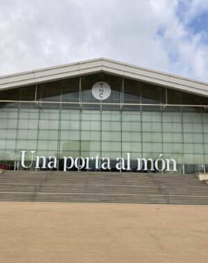 Sara Barros Leitão Instagram - Memórias de uma viagem a Barcelona para encenar uma leitura de um texto que escrevi para o Teatro Nacional da Catalunha. 

Este ano, foi Portugal o país escolhido pelo Teatro Nacional da Catalunha para se apresentar na Dramaturgia Emergente Europeia. Passei uma semana em Barcelona, guiada pela mão conhecedora do Manuel Tur, que encenou uma leitura do texto da Joana Craveiro, "Viagem a Portugal", enquanto eu encenava uma leitura do texto que escrevi propositadamente para este momento, "Regras para um beijo". É difícil descrever o quão bem recebidos fomos. Tínhamos um palco e uma equipa à nossa espera, e pudemos criar as leituras à escala do que éramos capazes de imaginar. Não fomos comedidos no amor que entregámos aos nossos atores, que confiaram em nós, na nossa direção e, no meu caso, que gentilmente me ofereceram a oportunidade de ouvir pela primeira vez o meu texto nas vozes de outros. Assim como entregámos parte do nosso coração e da nossa gratidão a toda a equipa que nos acolheu, que nos escutou, que assistiu atentamente a todos os ensaios, que imaginou soluções e antecipou problemas. O companheirismo, dedicação e rigor do Adrià Pinar foi essencial. Entrou nas nossas cabeças e transformou em luz, som e cenário a forma das nossas ideias. 

A par disso, há mais uma coleção de fotografias que não partilho aqui, mas que me acompanharão na memória de uma viagem maravilhosa. Visitámos a Sala Beckett, vimos um espetáculo brilhante no Teatre Lliure, comemos muito Ramen, batatas bravas e anchovas, vimos uma exposição sobre o SAAL e sobre processos semelhantes em Espanha e Itália nos pós-didaturas, caminhámos muito, fomos legalmente assaltados quando descobrimos o preço do brunch que acabáramos de comer, comprámos livros de teatro, conversámos sobre teatro e sobre a vida, aprendi palavras em catalão e ensinei palavras em português.

E tive muita sorte de poder partilhar toda esta experiência com o Manel, com quem aprendi sem que ele soubesse, enquanto o via a trabalhar, a encenar, a dirigir e a criar. 

O meu texto imaginava o que os fantasmas faziam nos teatros vazios. Mas é mesmo bom quando podemos chateá-los e preencher os teatros de pessoas e ideias.