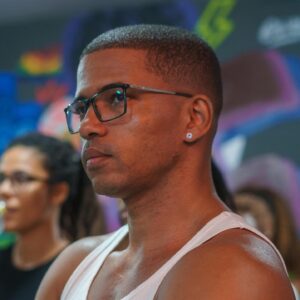 Sol Miranda Instagram - Foi uma experiência transformadora mediar a mesa de conversa sobre afeto na Yolo Love Party. Esse espaço de troca é um verdadeiro exercício de generosidade, onde ouvir o outro e suspender nossas certezas se reafirmam enquanto práticas essenciais em uma sociedade que frequentemente exige posicionamentos. 

Tivemos perspectivas diversas e enriquecedoras sobre o amor e o afeto com as contribuições de Renato Noguera, Camila Ribeiro do Projeto Ibejix, Jorge Mais Um do Projeto Papo de Baile, e a cantora e historiadora  Azula.

@noguera_oficial , em seu livro “Por Que Amamos?”, explora o amor como um ato coletivo e profundamente p0líT|c0. Ele afirma que “o amor é uma prática coletiva que envolve a construção de um mundo mais justo e igualitário”​ (Trechos Org)​. Noguera propõe que o amor vai além das emoções individuais e se estende à comunidade, desafiando-nos a repensar nossas relações de forma mais inclusiva e solidária.

Em plena comunhão com esse pensamento, o Projeto Ibejix, liderado por @camillaribeiror, centra-se na primeira infância a partir de uma perspectiva afrocentrada, enfatizando a importância do afeto e da identidade cultural no desenvolvimento das crianças negr4s. 

A conversa sobre masculinidades negr4s, trazida por @jorgemaisum ,reforçou como o amor e o cuidado são essenciais para desconstruir estereótipos e construir identidades mais saudáveis e positivas.

@azuladacordomar , com sua trajetória como mulher trans e artista, trouxe uma dimensão poderosa sobre como o amor e a aceitação são fundamentais para a luta por direitos e reconhecimento. Azula lembrou a todes da importância de um amor que acolhe e respeita as diferenças, promovendo a inclusão e a igualdade.

Discutir o amor sob essa ótica de organização e compreensão profunda é vital. O amor precisa ser entendido, exercido e cultivado para não ser confundido com paixão efêmera. Através do diálogo e da escuta, podemos construir relações mais autênticas e transformadoras.

Agradeço a todos os participantes pela riqueza das discussões e à equipe da Yolo por proporcionar um evento tão significativo. 

📸 : @odoro_guilherme