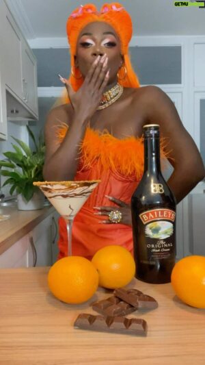 Vanity Milan Instagram - #Ad Did somebody say orange?🧡🤭 Let me show you how to make the perfect chocolate orange martini cocktail for halloween with my favourite drink for every occasion @baileysofficial 

Ingredients:
50ml of Baileys Original Irish Cream
25ml of triple sec
75ml of Milk of your choice

(Image Description) The scene oozes orange indulgence, with a woman dripping in divine orange jewels and wearing a delicious bright orange ensemble — lavish orange wig included. A bottle of Baileys Original Irish Cream, a trio of juicy oranges and sprinkling of sweet chocolate sit on a table in front of her. With the snap of a finger, a cocktail tutorial commences. She places a cocktail shaker down and adds a handful of round ice cubes, pouring in the add milk here 50ML of creamy rich Baileys Original Irish Cream, and 25ml of triple sec to add a citrus boost. Then, it’s shake, shake, shake! To amp up the decadence, she coats the brim of her martini glass in dark chocolate and rolls it into a plate of crushed cookies. The velvety liquid from the cocktail shaker is poured into the cookie rimmed martini glass, and she takes a sip. A divine drink for celebrating the Halloween season!